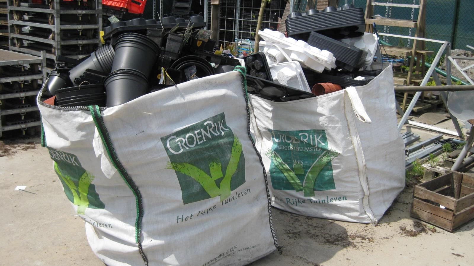 Tomme plast-urtepotter samlet i sække bag havecenteret Groenrijk