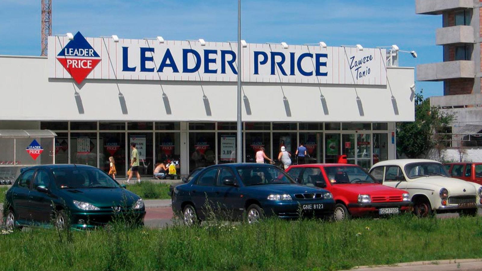 På P-pladsen foran et Leader Price supermarked holder fire personbiler