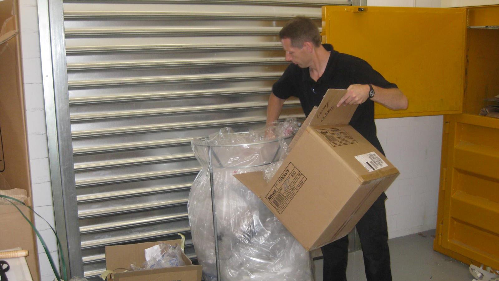 Medarbejder fra Media Markt kommer blødt plastaffald i et affaldsstativ
