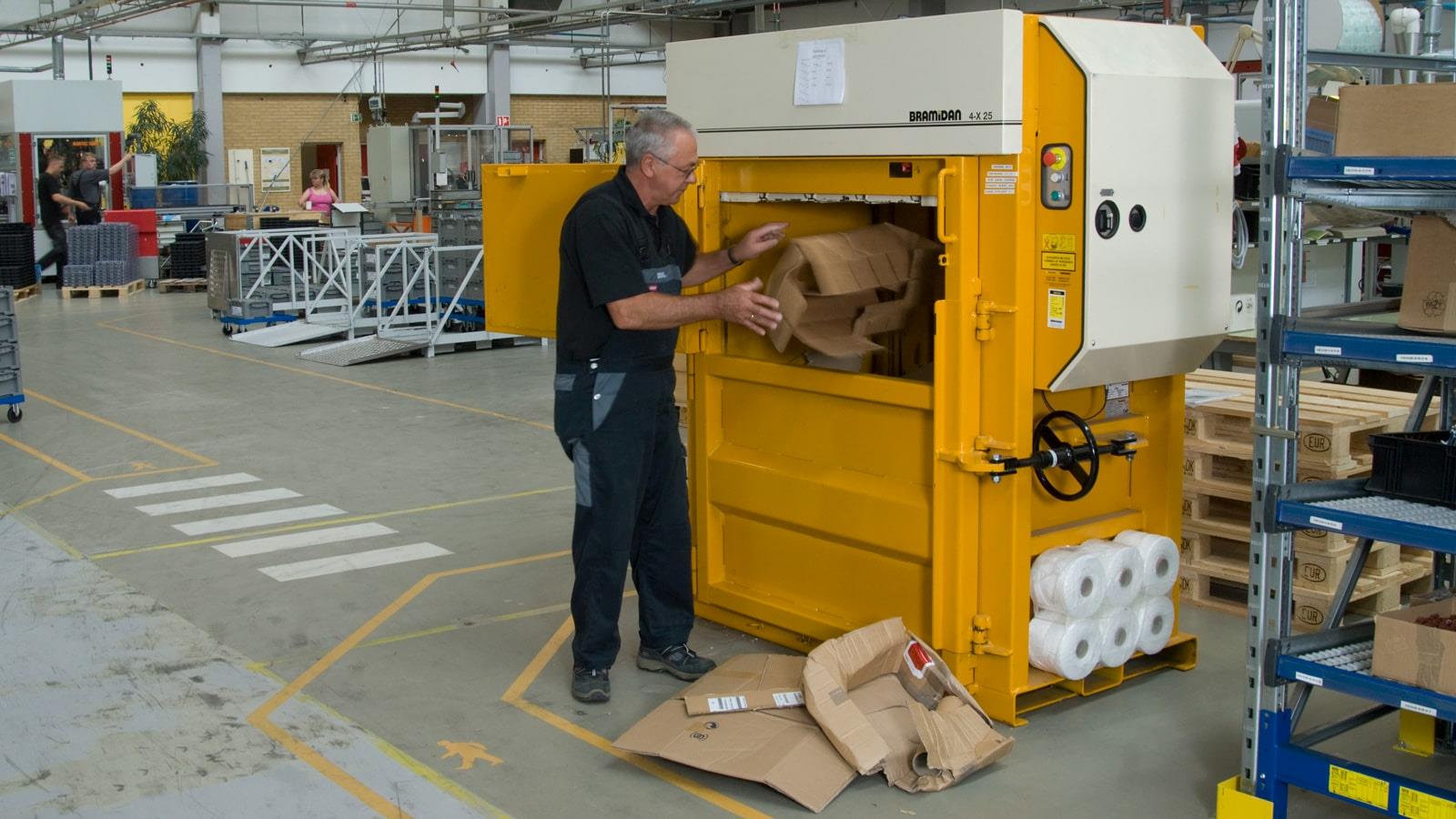 Sauer-Danfoss medarbejder smider papkasser i Bramidan ballepresser